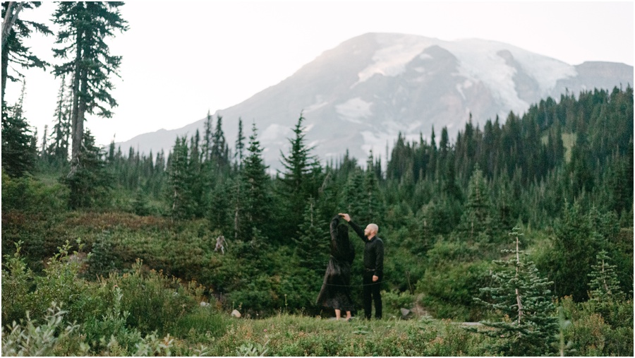 Couple dancing & twirling in front of Mt Rainier at their engagement session