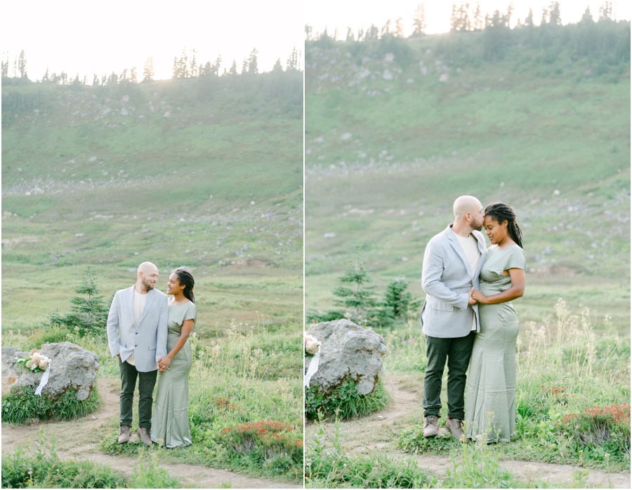 Couple with arms around each other and holding hands at their dressy Seattle engagement session in the mountains.
