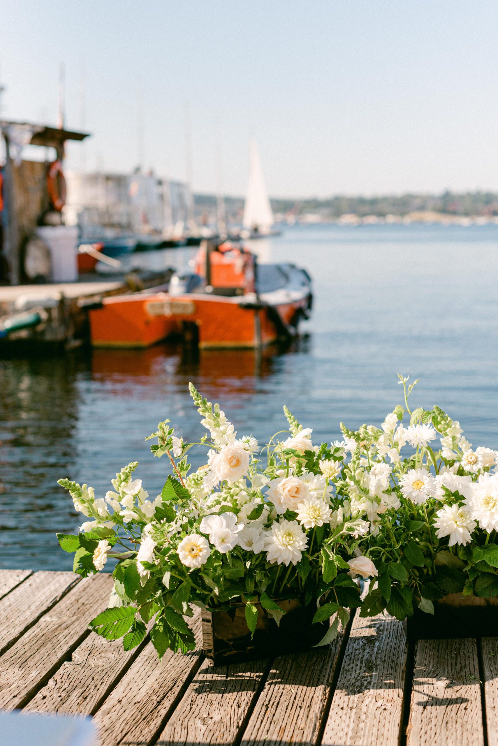 Seattle Washington, The Center for Wooden Boats Wedding Venue. Wedding floral arrangement on the docks. Water and boats in the background.