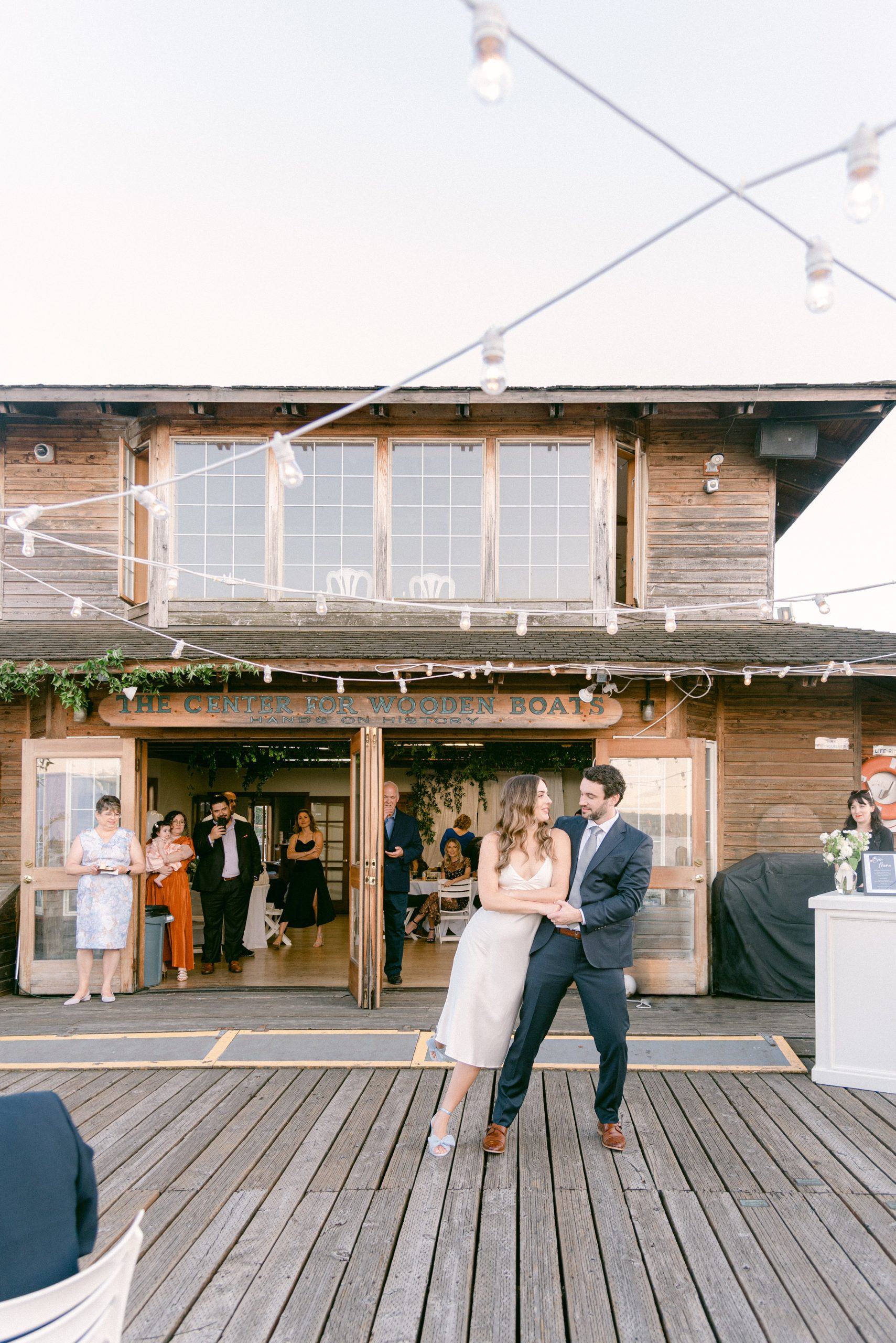 Fine Art Weddings in Seattle Washington. The Center for Wooden Boats, Bride and Groom share their first dance with the venue behind them.